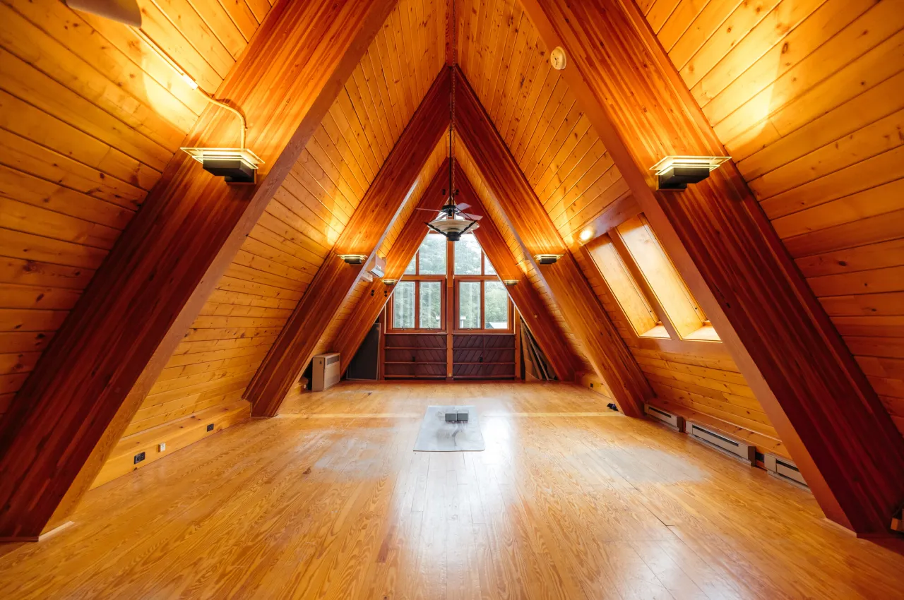 A yoga studio in an A-frame structure crafted with warm wood and soft light. 