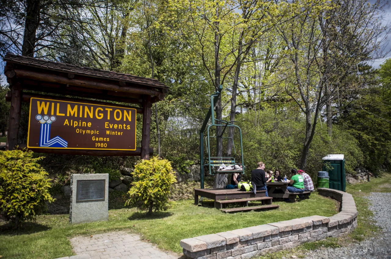 A sign for Wilmington's alpine events with a vintage chair lift next to it.
