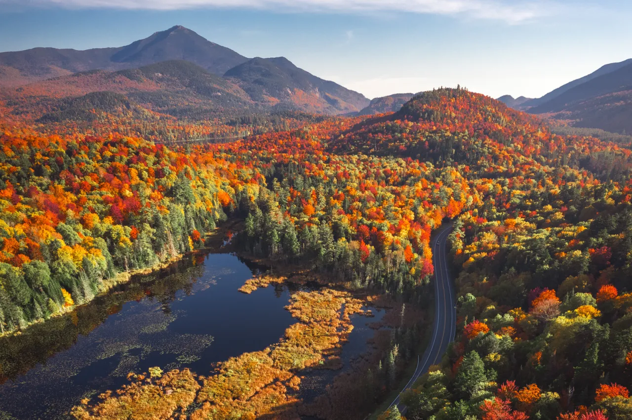 view of whiteface and river in the foreground with fall vibrant fall foliage