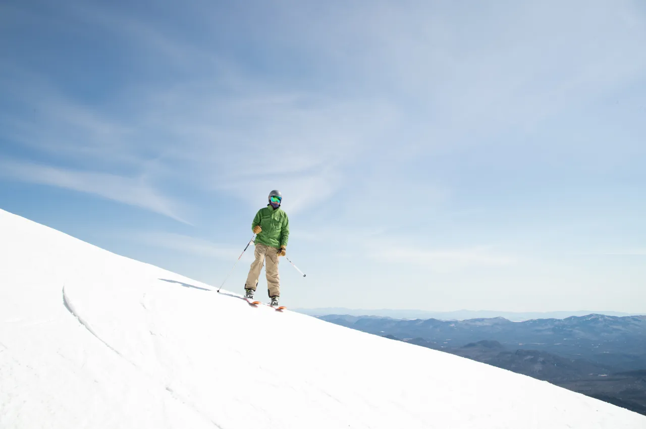 A skier stands on a snowy slope