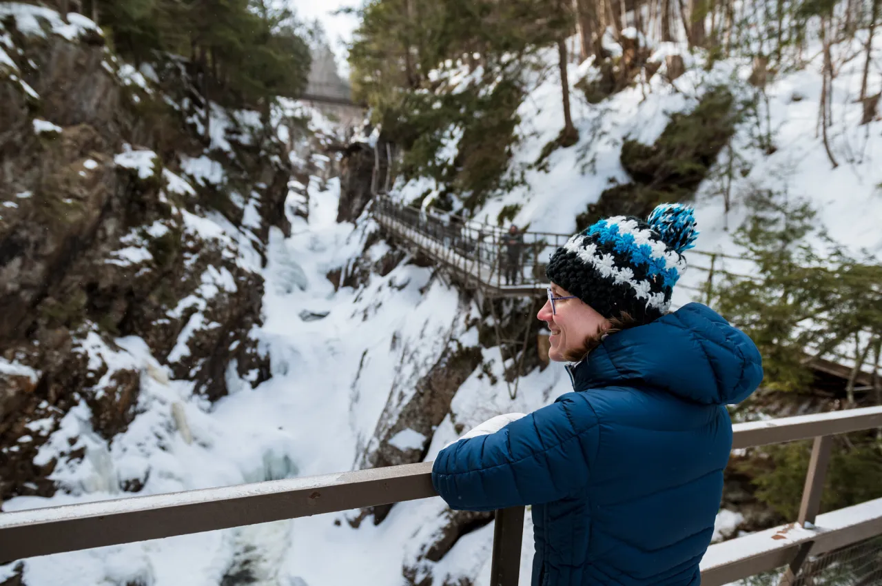 A hiker takes in views of a narrow, icy gorge