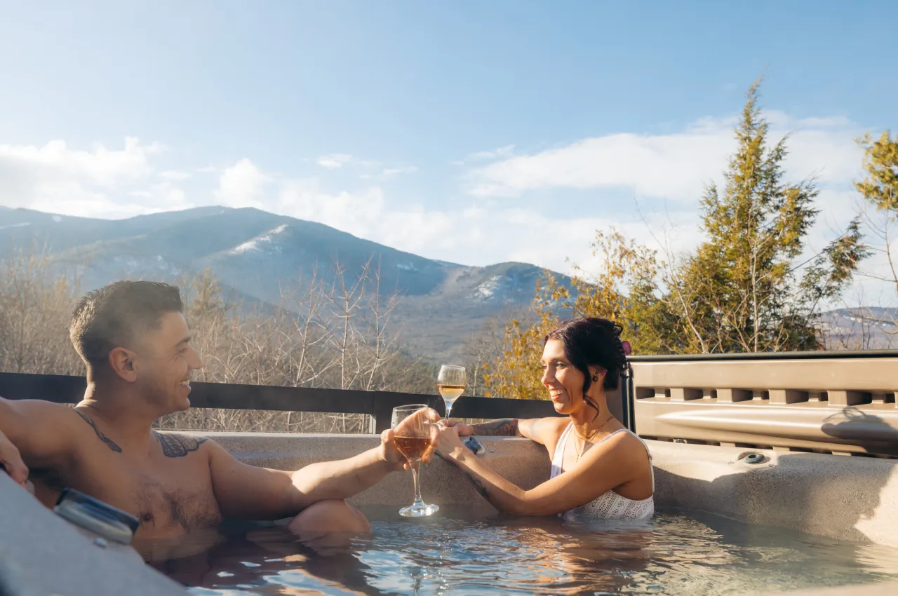 A couple in a hot tub at the Algonquin Chalet during winter.