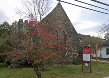 An old stone church with a flowering tree