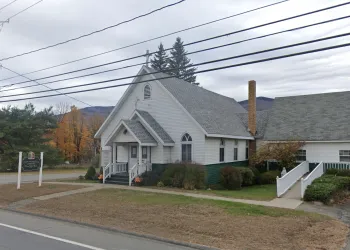 Roadside view of the quaint white church entrance.
