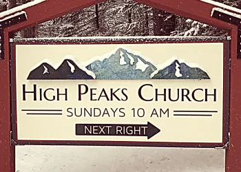 A sign for the entry to High Peaks Church blanketed in light snow