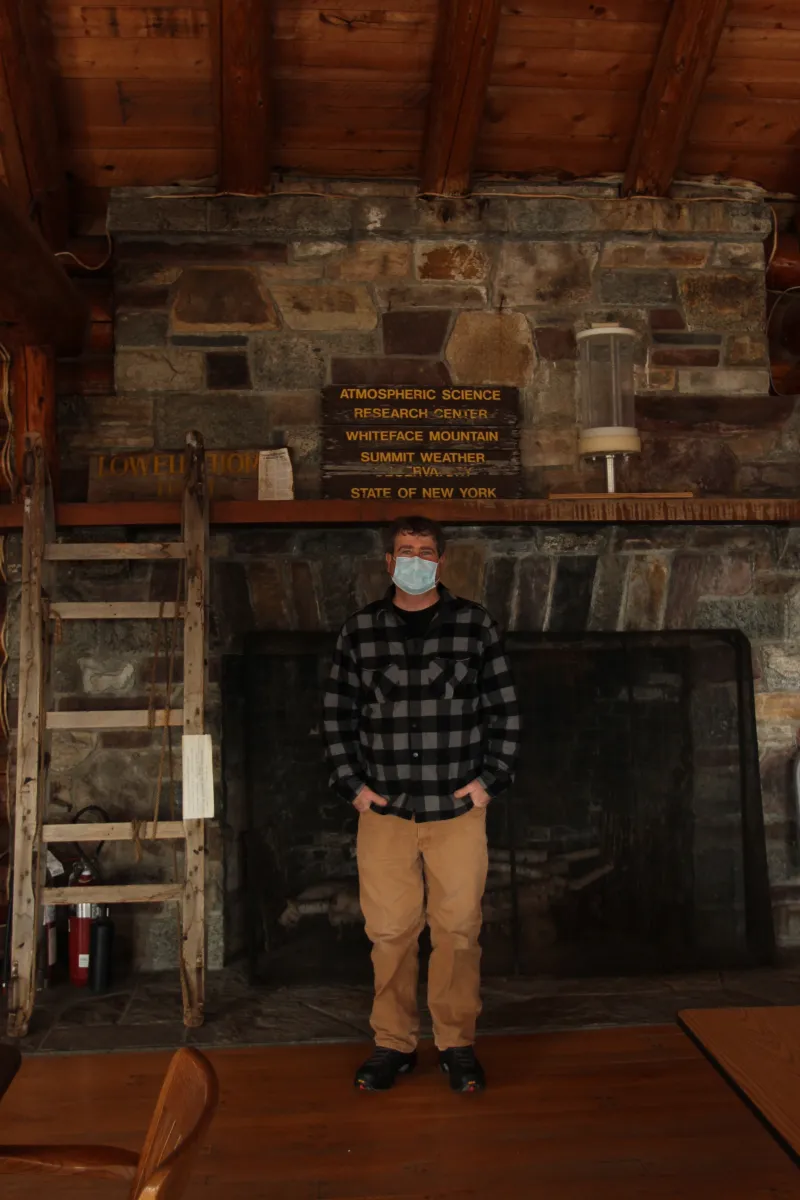 Paul Casson stands in the ASRC lodge. An old cloud collector sits on the mantel to his left.