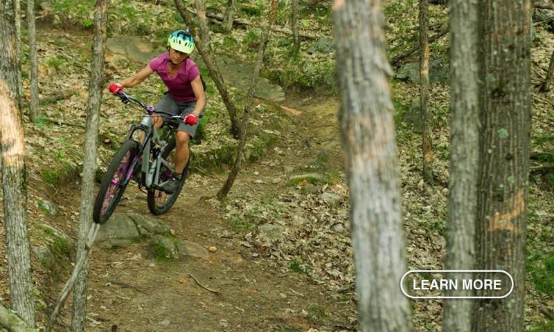 A woman mountain biking on the rugged trails of the Whiteface Region.