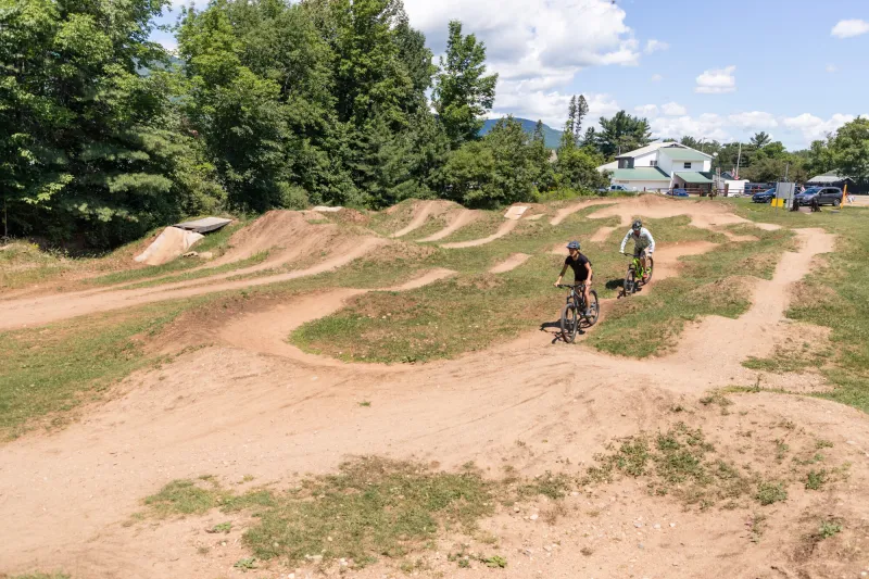 Two mountain bikers ride through the pump track at the Wilmington Bike Park