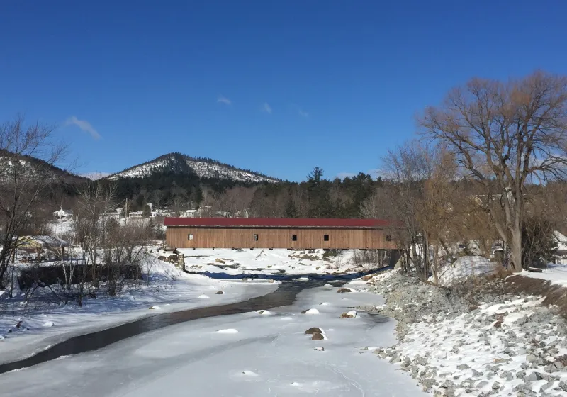 Winter looms over a Covered Bridge with the Ausable River frozen below.