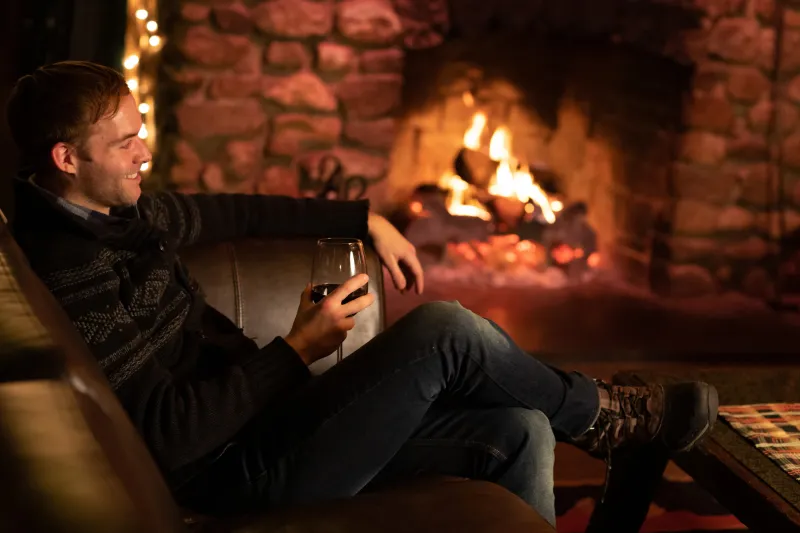 Man sitting in front of a fireplace