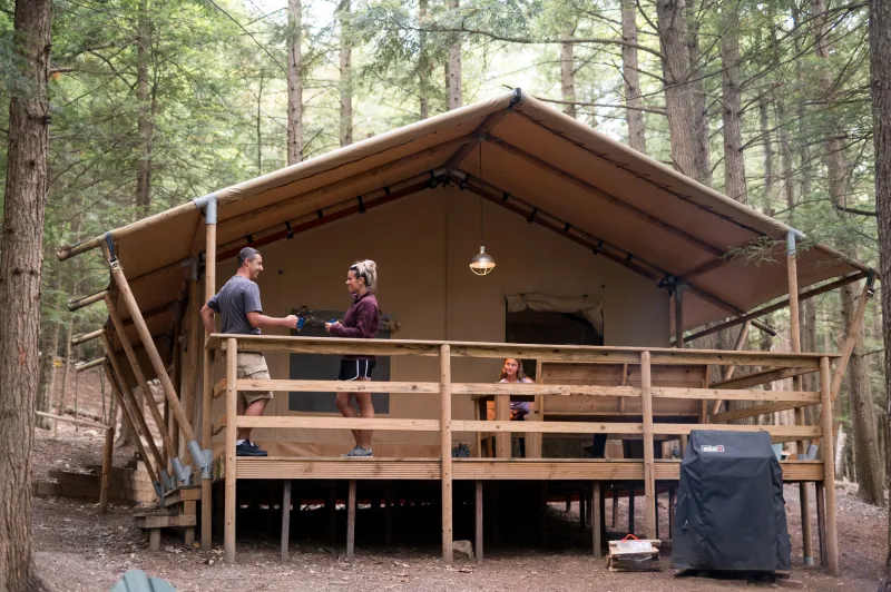 a family hangs out on a canvas covered cabin.