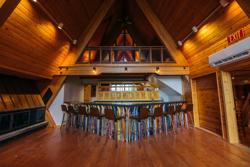 A brilliant wooden A-frame building over a bar made of cross-country skis.