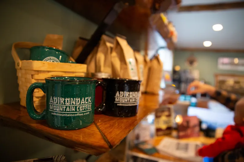 Two coffee mugs sit on a shelf at the Adirondack Mountain Coffee cafe