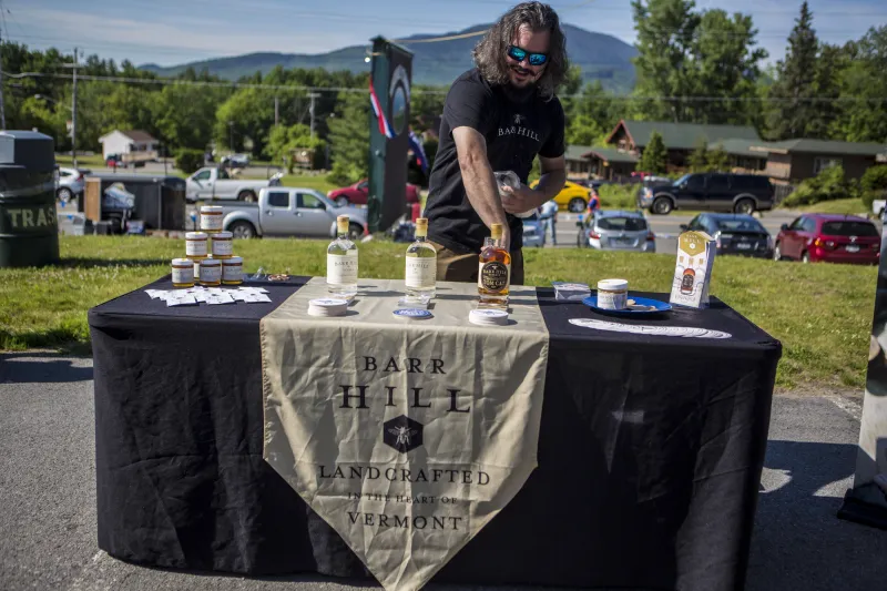 A man tends a whiskey stand serving samples of liquor.