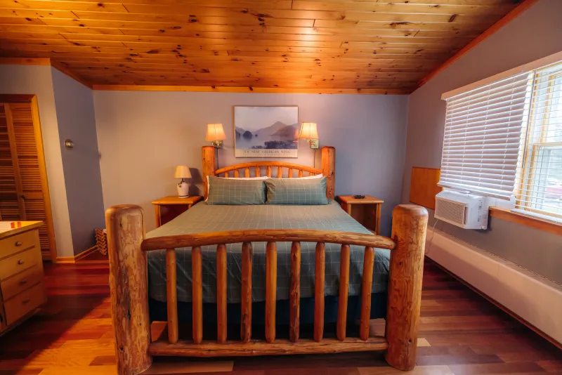 A rustic-style Adirondack hotel room featuring a log bed.