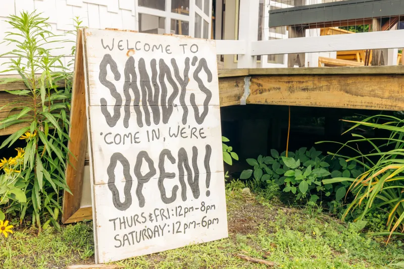 Sandy's open sign outside of their patio seating area.