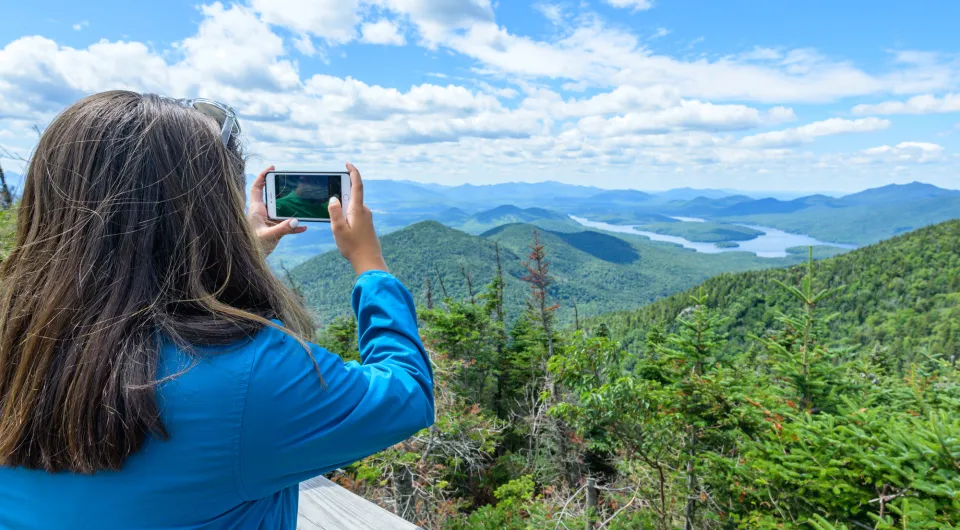 a woman takes pictures of the mountains