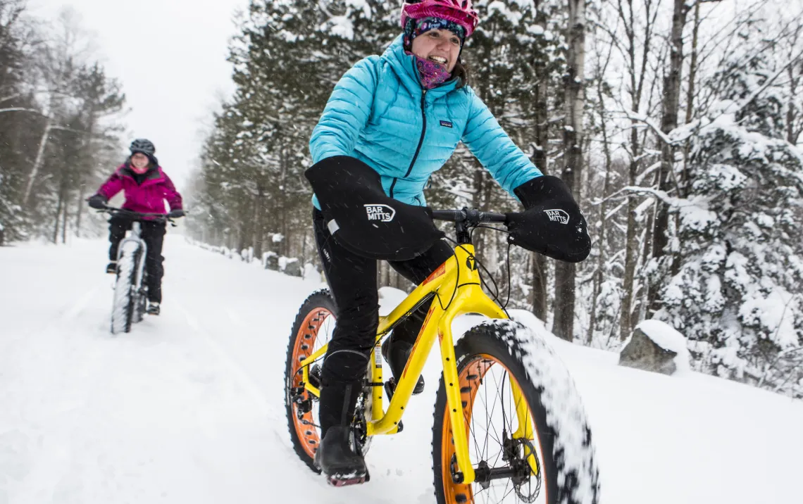 Two people fat tire biking on snow