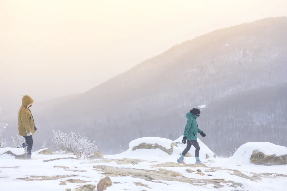 Man and woman snowshoe on summit