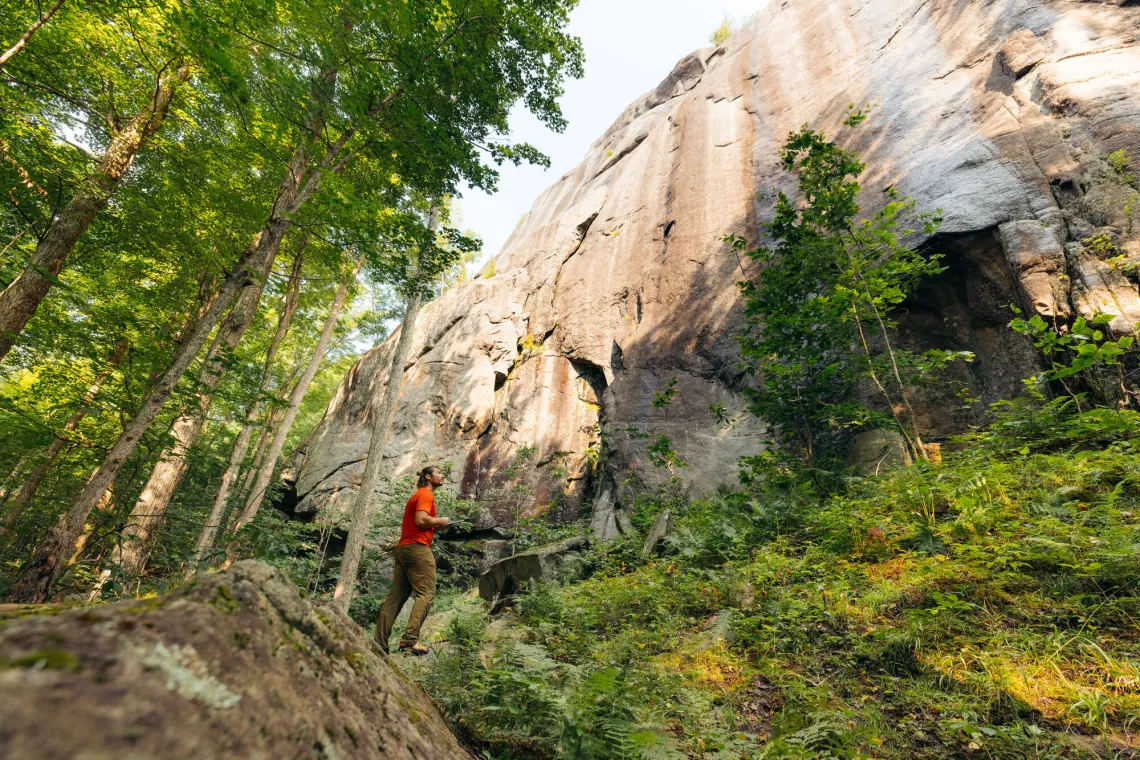 Climbers look at map sitting at base of cliff