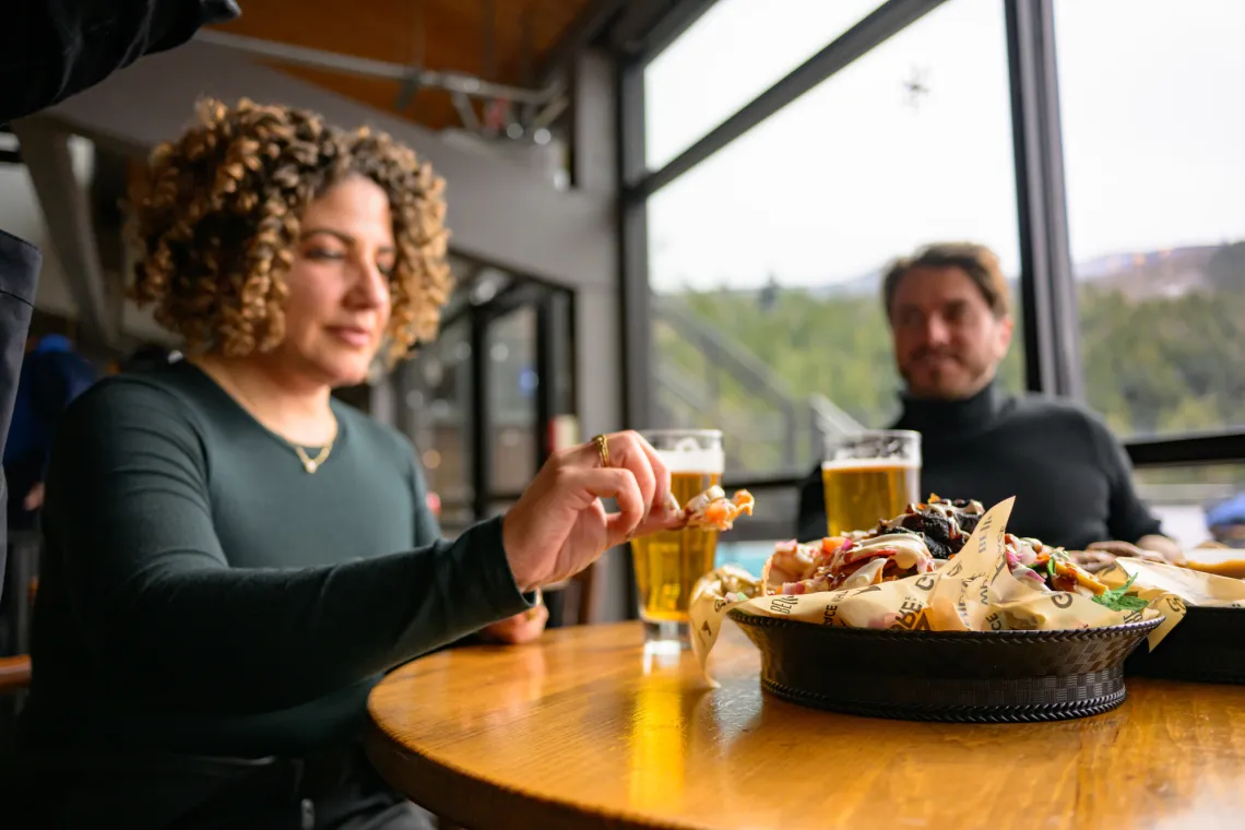 Woman picks up nacho off plate