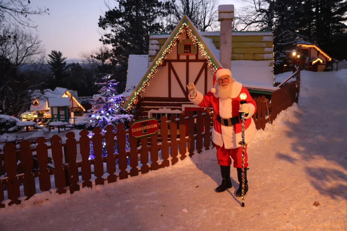 Man dressed as Santa stands in front of North Pole amusement park