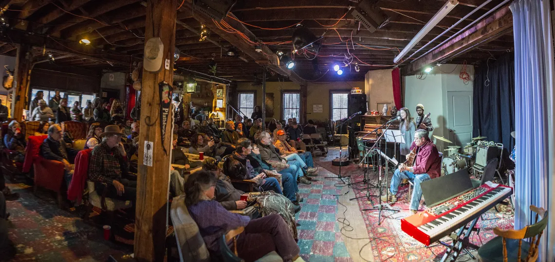 A concert in a basement with a large crowd.